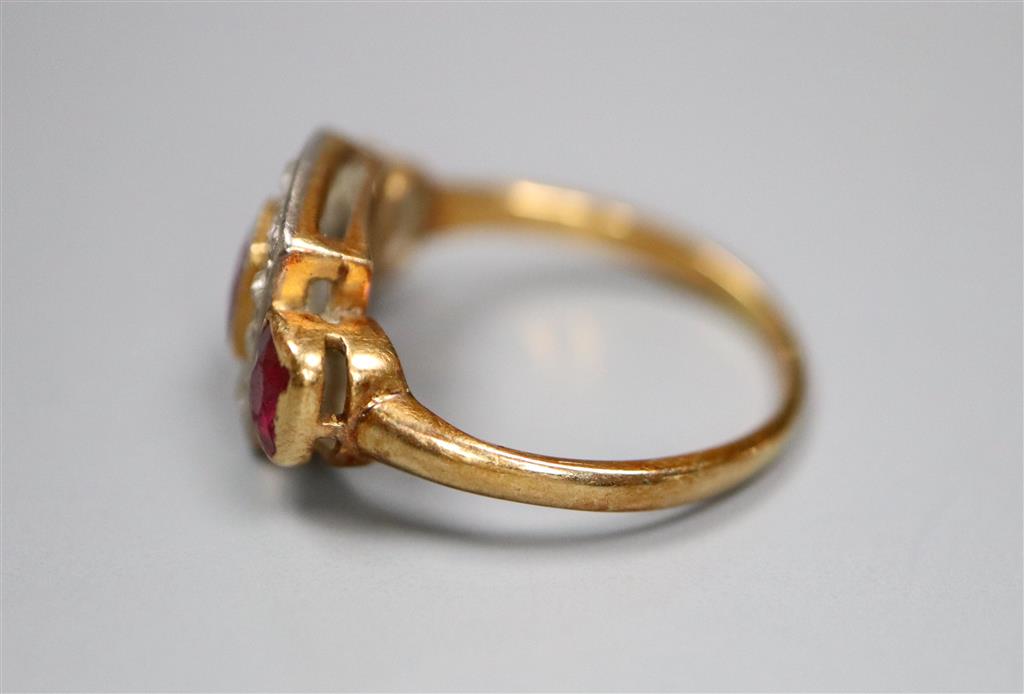 An early 20th century yellow metal, ruby and diamond cluster ring with ruby set shoulders, size K, gross 3.6 grams.